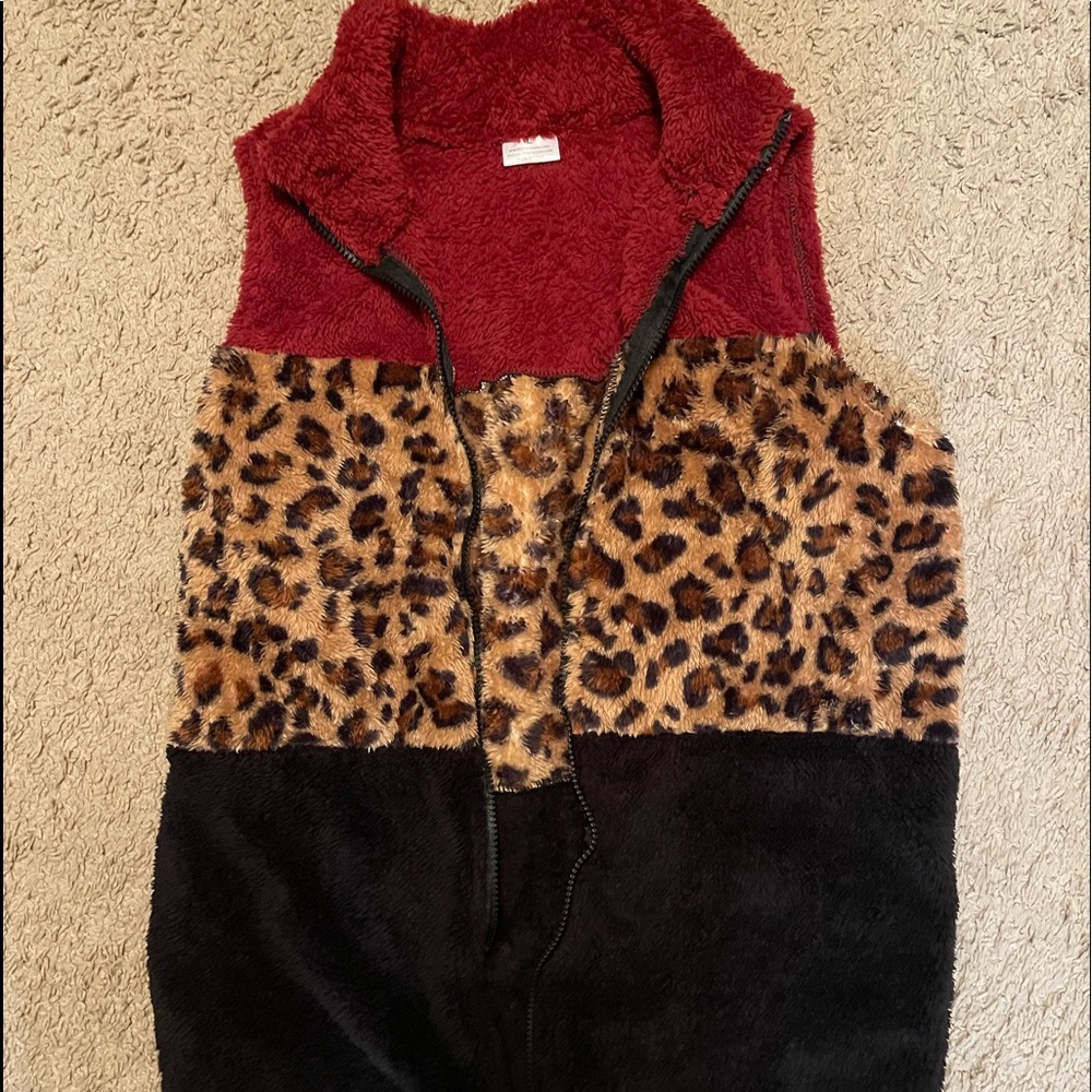 A black, maroon, cheetah vest